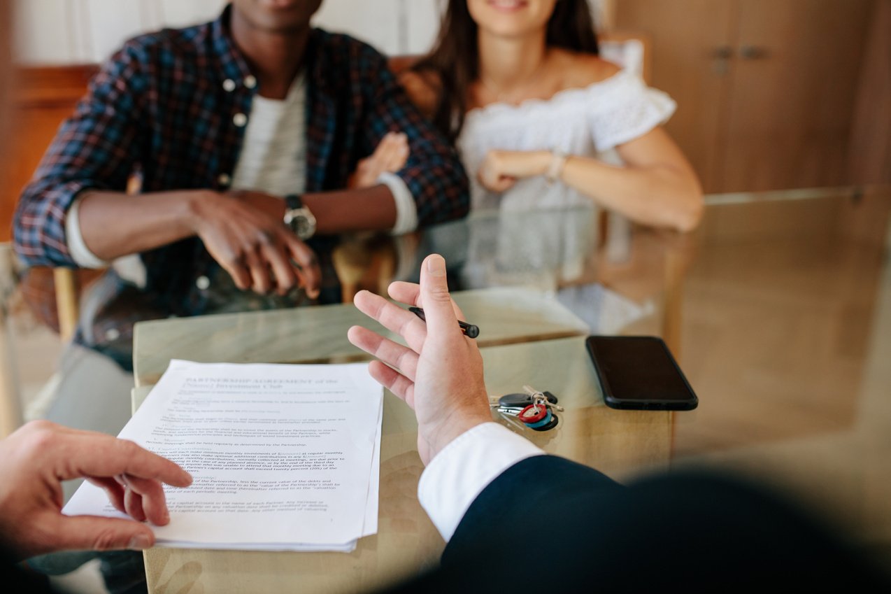 Realtor Explaining Details of Lease Agreement to Couple